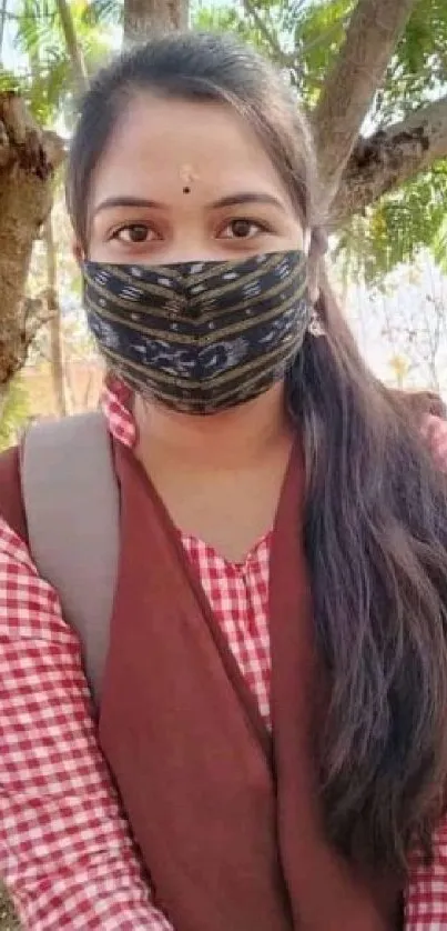 Person wearing a mask in nature with trees.