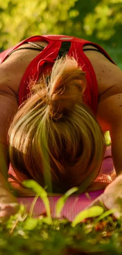 Yoga pose on grass under green trees.