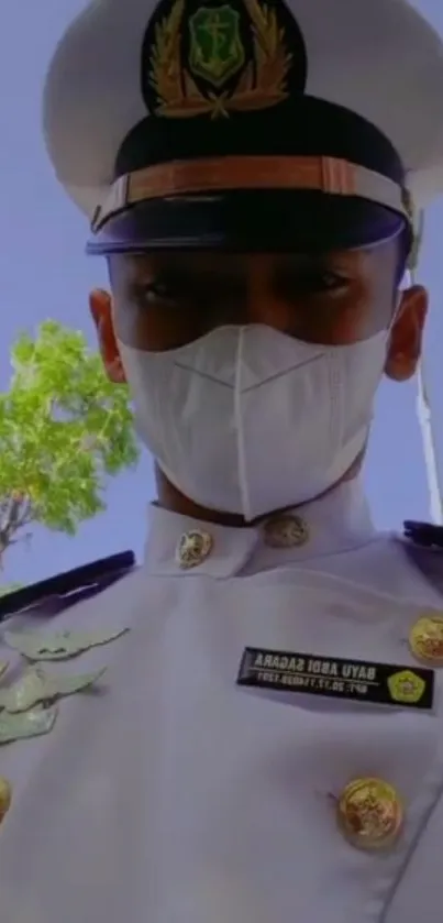 Naval officer in white uniform and hat under clear sky.