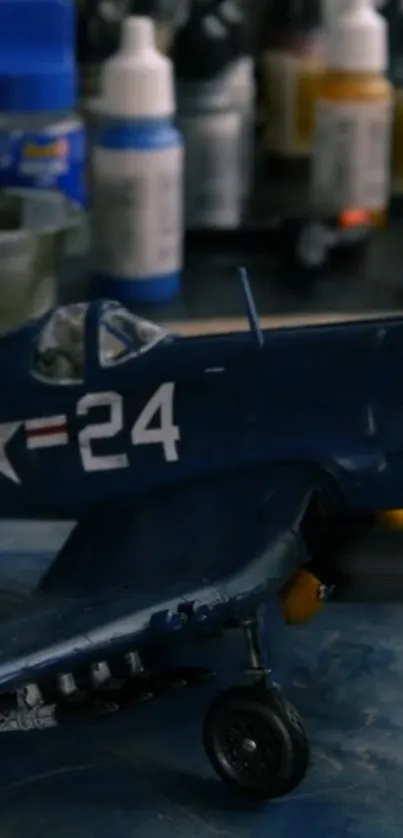 Model of a navy aircraft with paint jars on a workbench.