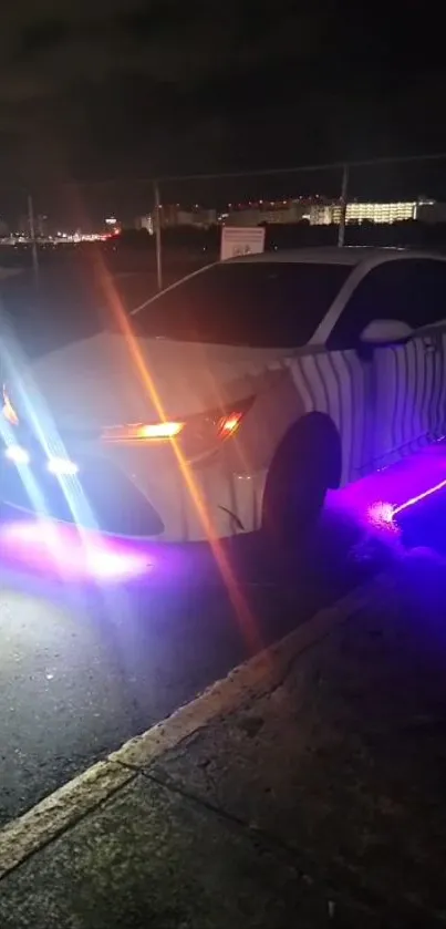 Car with neon lights and purple underglow at night in an urban setting.