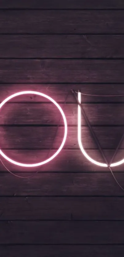 Neon letters glow against a dark wood background.