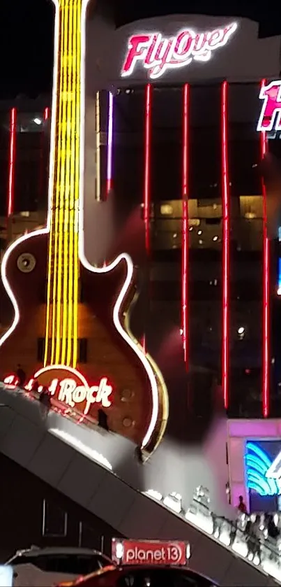 Neon guitar cityscape at night featuring bright red and yellow lights.