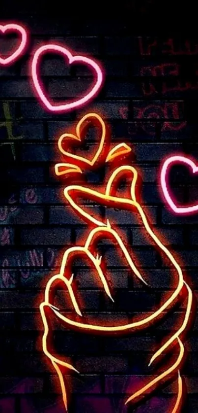 Neon heart gesture on dark brick wall with vibrant colors.