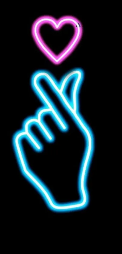 Neon hand gesture with heart glowing in pink and blue on black background.