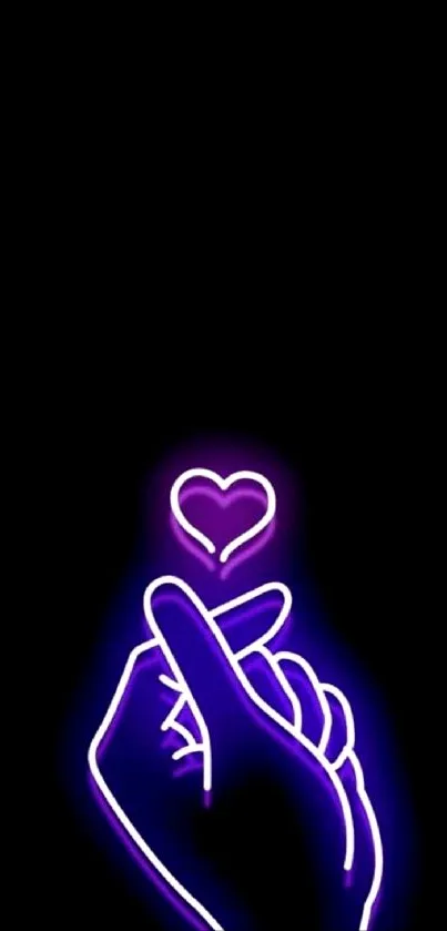 Neon heart hand art on black wallpaper.