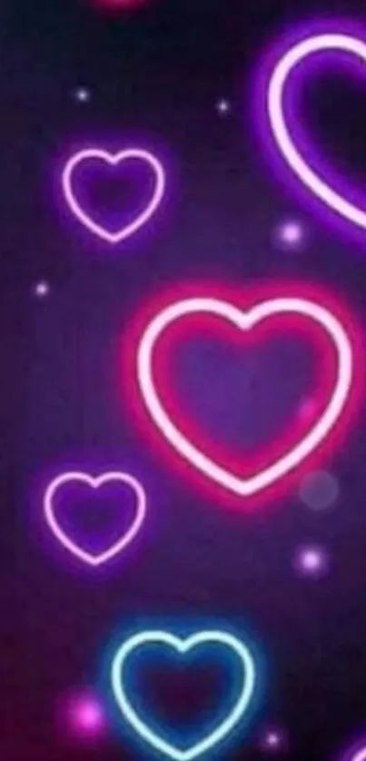 Vibrant neon heart wallpaper with pink and blue glowing designs.