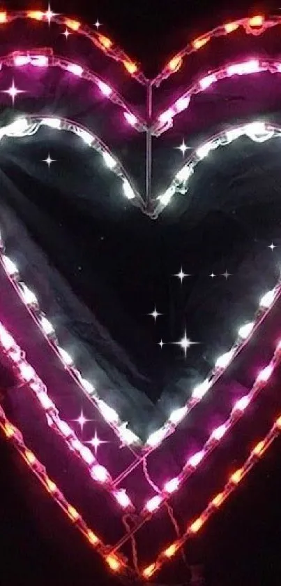 Colorful neon heart lights on dark wallpaper.