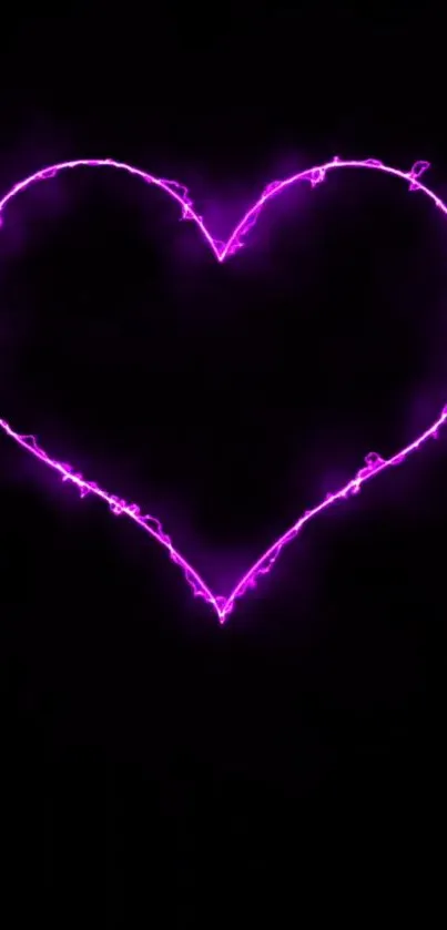 Pink neon heart glows on a black background.