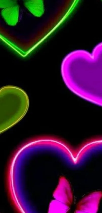 Vibrant neon hearts and butterflies on a black wallpaper.