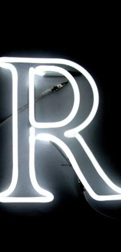 Neon letter R glowing against a black backdrop.