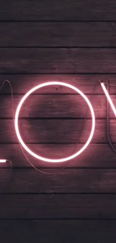 Pink neon 'Love' sign on dark wood background wallpaper.