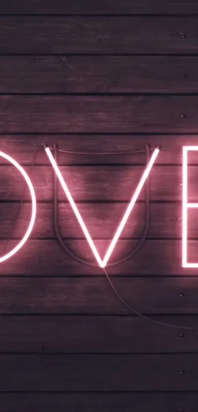 Neon pink love letters on a wooden background.