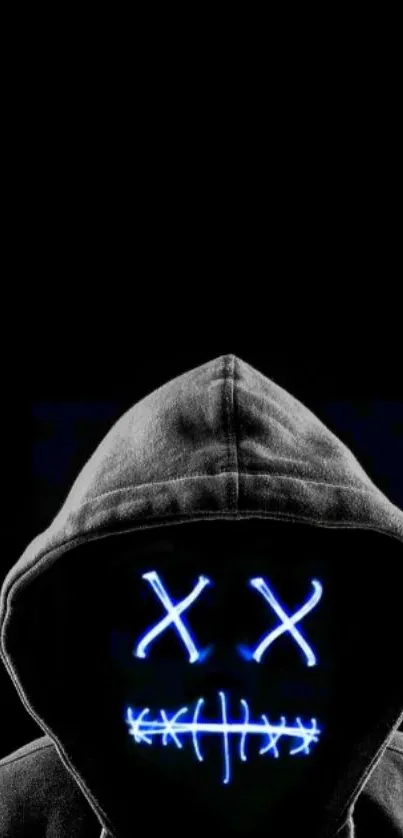 Hooded figure with neon mask on dark background.