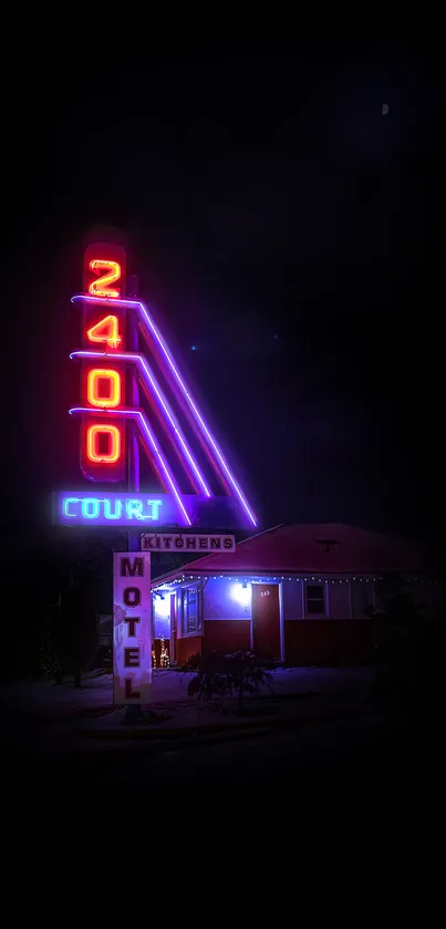 Neon lit 2400 Court motel sign at night.