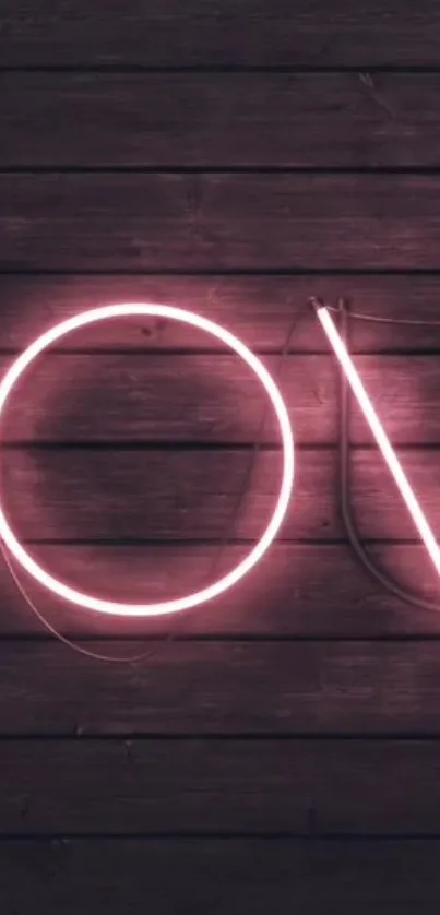 Neon pink love sign on wooden background, vibrant glow.