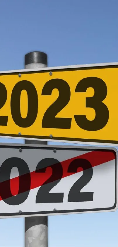 Road signs for 2023 and 2022 under a clear blue sky.