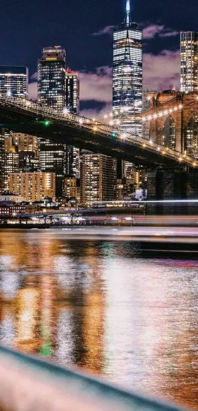 New York City skyline at night with reflections and Brooklyn Bridge.