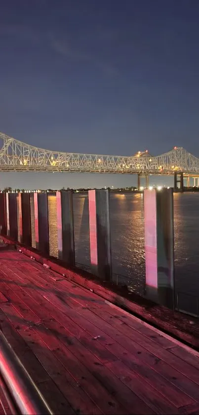 Night scene with illuminated bridge and water reflections.