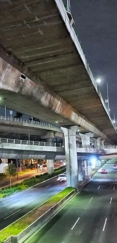 Nighttime view of a city highway under overpasses.