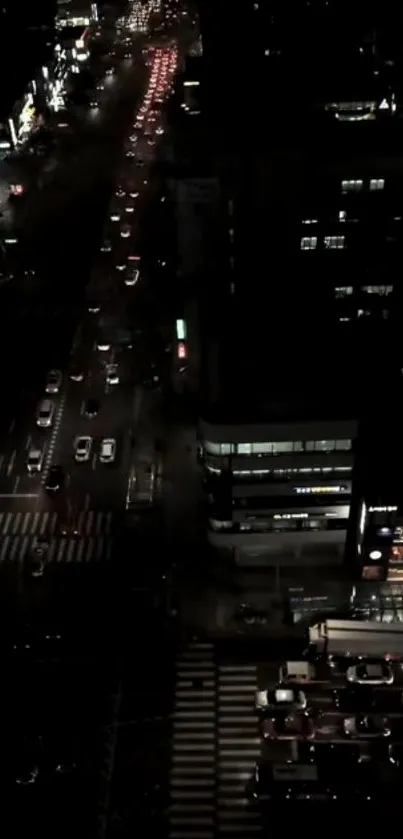 A nighttime aerial view of a city with illuminated streets and buildings.