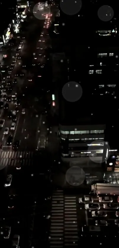 Nighttime view of a city street alive with lights and traffic activity.