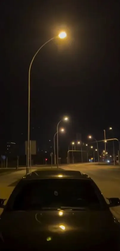 A nighttime scene of a quiet city street with glowing streetlights and a parked car.