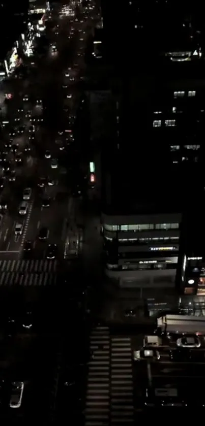 Aerial night view of a bustling city street with bright lights and traffic.