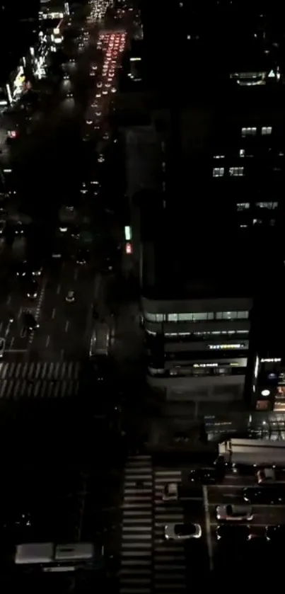 A bustling city street illuminated at night viewed from above.