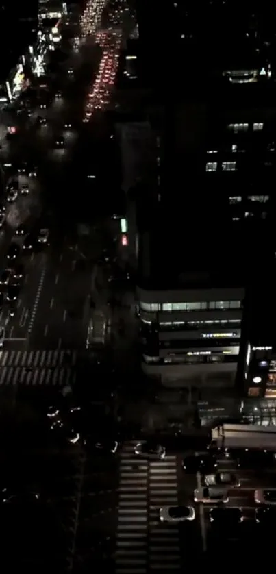 Nighttime cityscape showing busy street with cars and illuminated buildings.