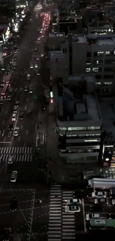 Aerial view of a busy city street at night with illuminated buildings.