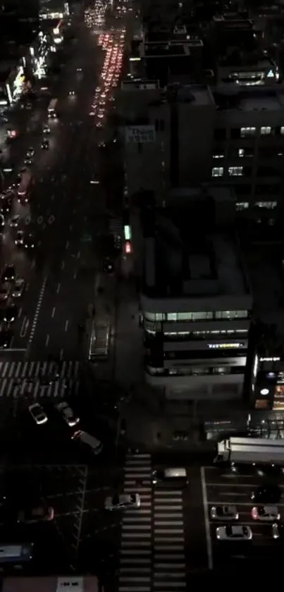 Aerial view of a city at night with busy traffic and illuminated buildings.