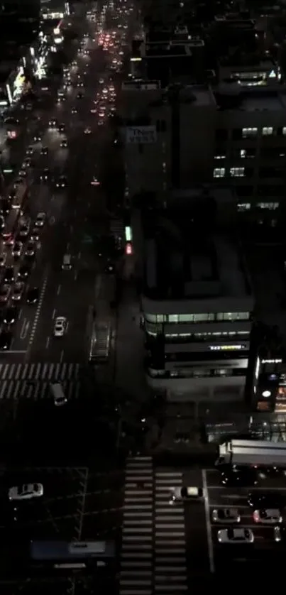 Aerial night view of bustling city streets illuminated by glowing lights.