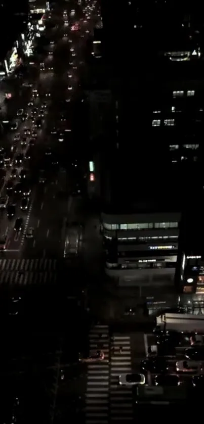 Aerial night view of a bustling city street with illuminated buildings.