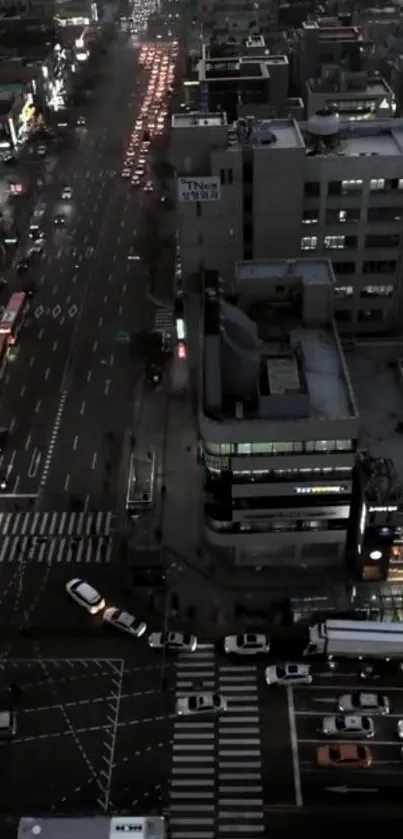 Aerial night view of a busy city street with glowing lights and modern buildings.