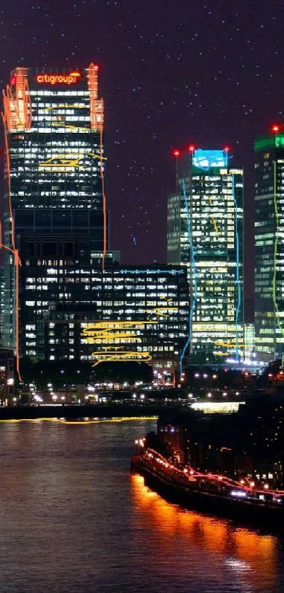 Illuminated city skyline at night reflecting on river waters, under a deep purple sky.