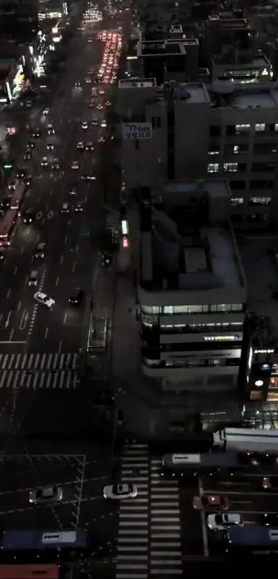 Aerial view of a city street at night with busy traffic and glowing lights.