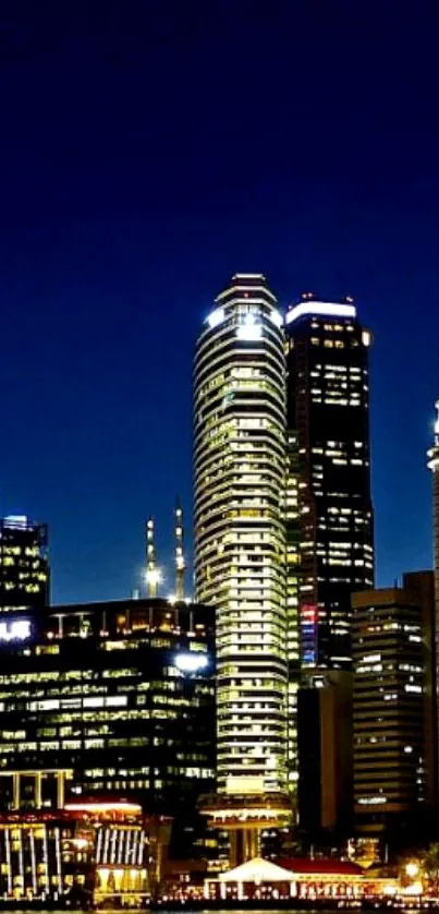 Night cityscape with illuminated skyscrapers against a dark blue sky.