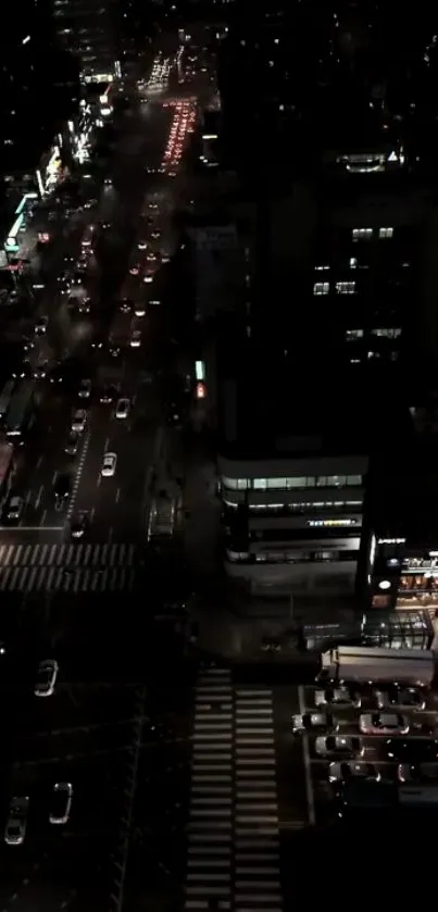 Night city street with buildings and traffic viewed from above.