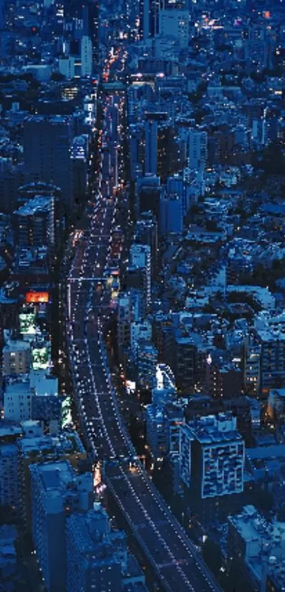 Aerial view of city at night, illuminated with bright lights and busy streets.