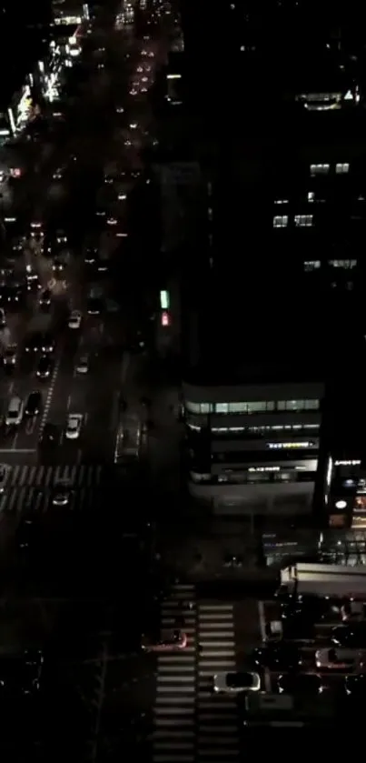 Aerial view of a city street illuminated at night with vibrant lights.
