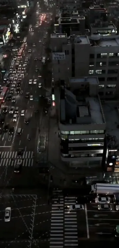 Aerial view of a city with night traffic and illuminated buildings.