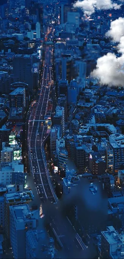 Aerial view of a cityscape at night with highway lights and clouds.