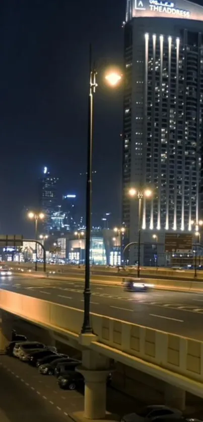 Cityscape at night with skyscrapers lit up and a busy road below.