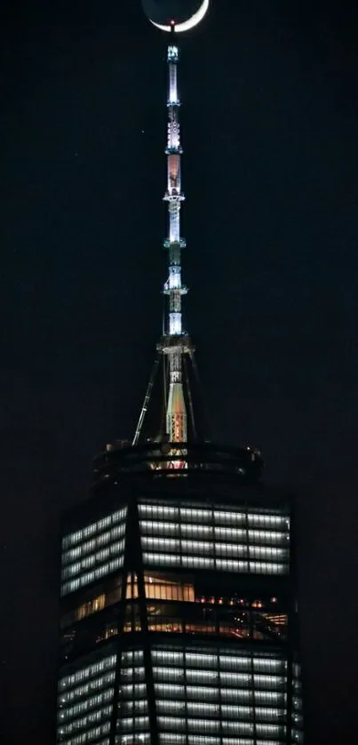 Crescent moon above a lit-up skyscraper at night.