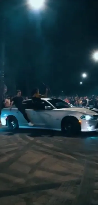 A car drifts on a city street at night with a crowd watching nearby.