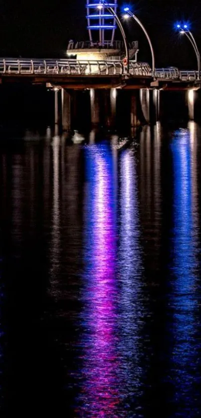 Mobile wallpaper of a lit pier at night with colorful reflections on water.