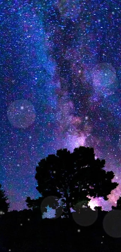 Silhouette of a tree under a vibrant starry night sky with blue and purple hues.