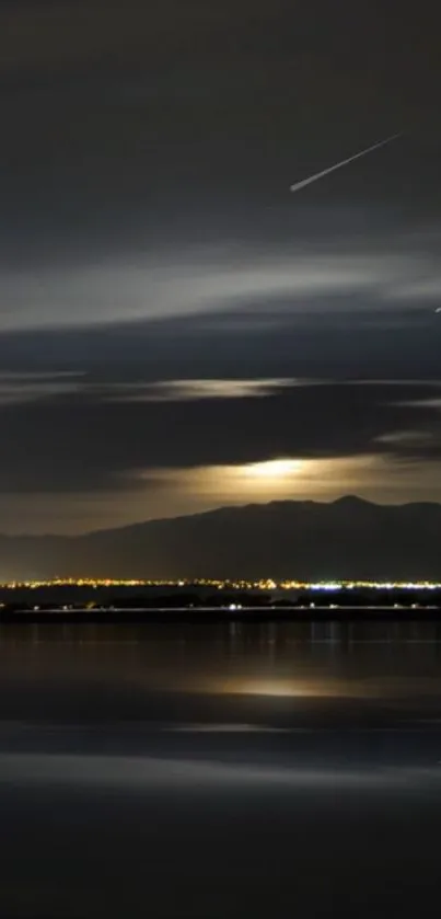 Night sky over a tranquil lake with distant mountains.