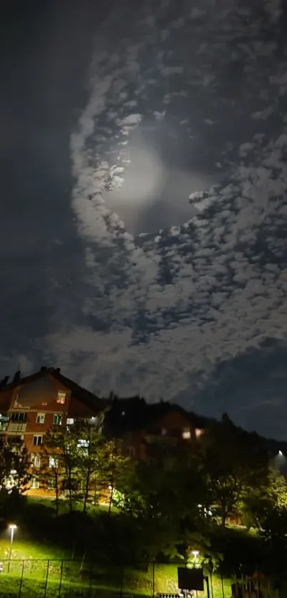 Moonlit night sky over urban houses with clouds.